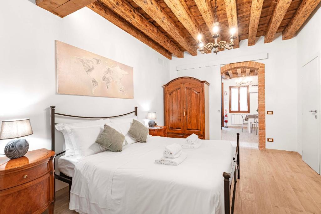 a bedroom with a white bed and a wooden ceiling at Armida Flat by Fenix in Venice