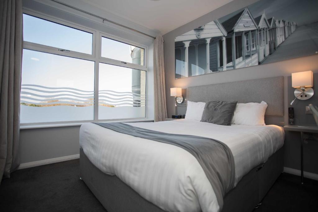 a bedroom with a large bed and a large window at The Harbour Post at Waterside Park in Corton