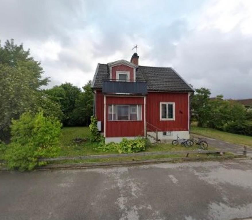 a red and white house with a parking lot at Central Villa Hultsfred Vimmerby in Hultsfred
