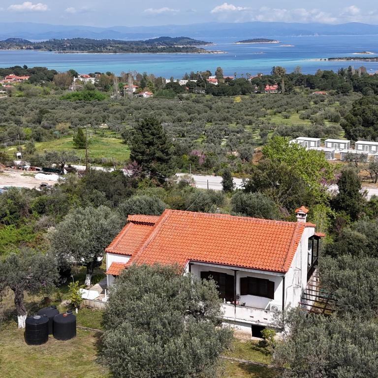 a small house with an orange roof on a hill at Aria Seaview Villa in Vourvourou
