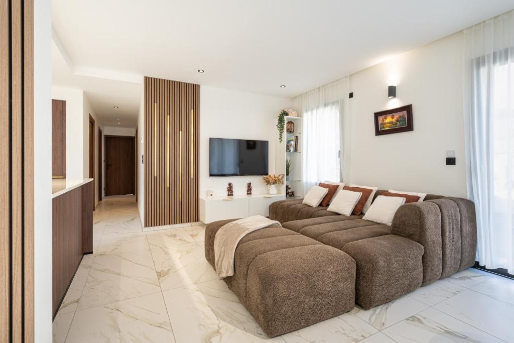 a living room with a couch and a flat screen tv at Villa belle rive RdC 3 chambres in Sévrier