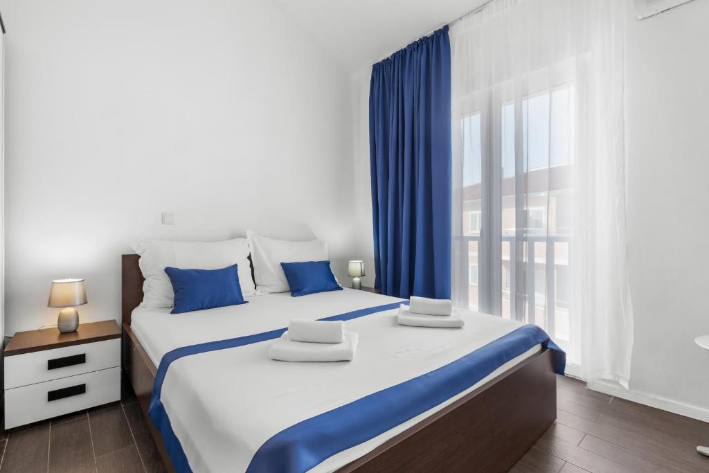 a bedroom with a large bed and a window at Lotus Oliva Apart in Premantura