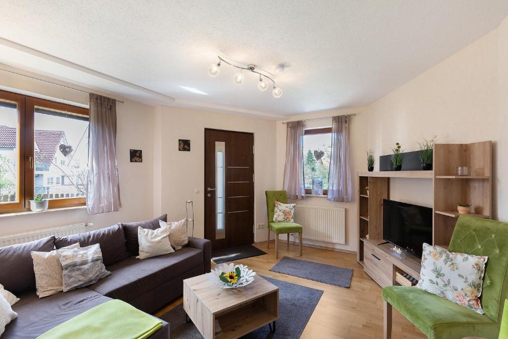 a living room with a couch and a tv at Ferienwohnung Hochspessart in Rothenbuch