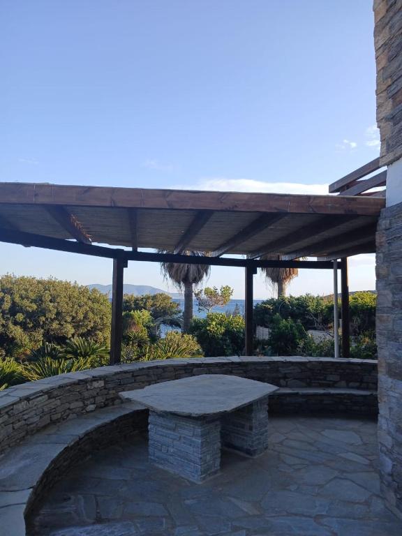 a stone bench under awning on a patio at Scenic Coastal Getaway in Porto Lafia