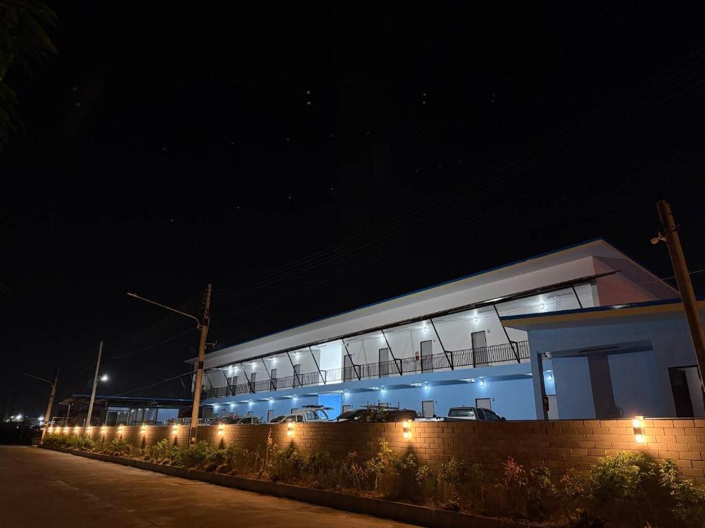 a building with lights in front of it at night at K-Am คราม อมตะ รีสอร์ต in Ban Yan Su