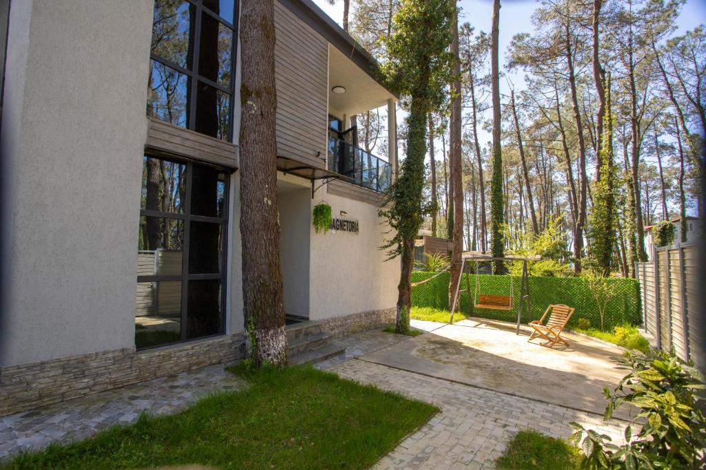 a house with a bench in front of it at Magnetoria 3 BR House in pine forest - 3 mins to the sea in Urekis Sadguri