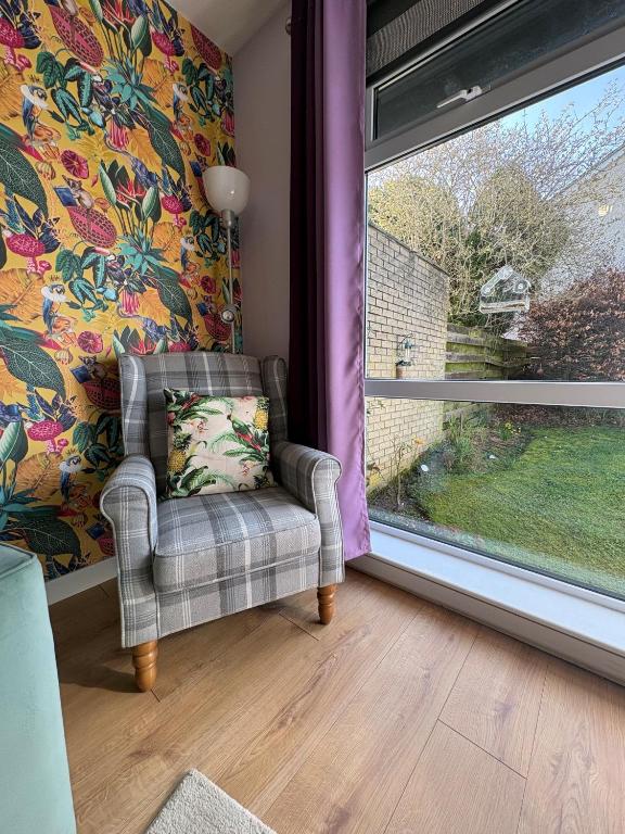 a living room with a chair and a window at Stillrovin Cottage in Stirling