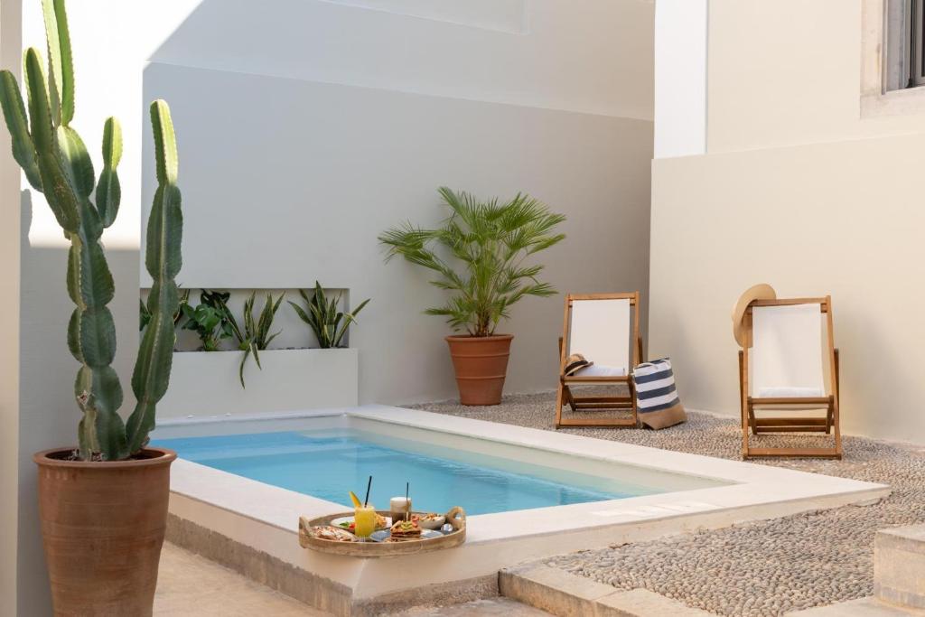 a swimming pool in a living room with plants at Gioma Luxury Villas in Agios Nikolaos