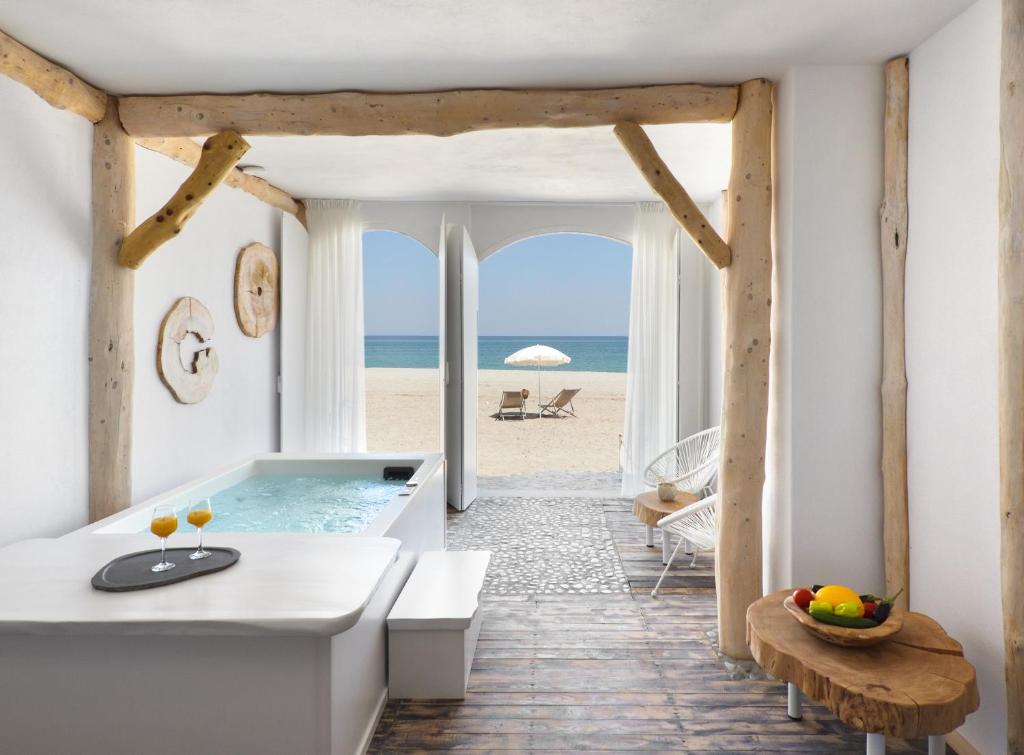 ein Badezimmer mit Badewanne und Strand in der Unterkunft Olympa Suites in Plaka
