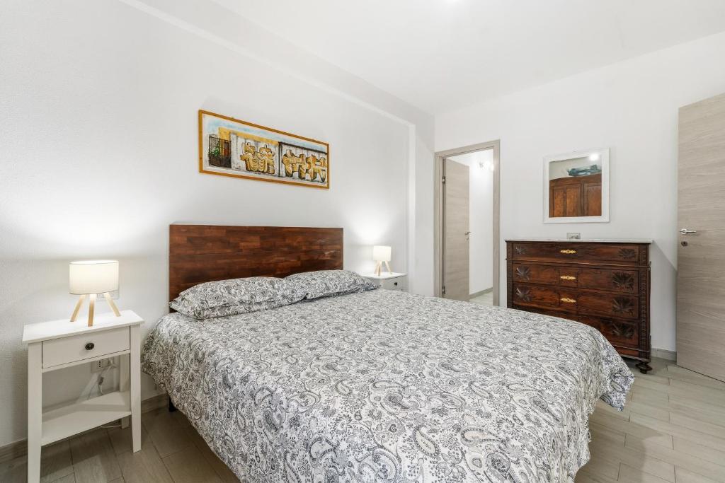a white bedroom with a bed and a dresser and a drawer at Casa Due Spighe in San Sperate