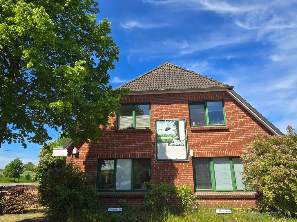 a red brick house with a tree at Ferienwohnung Kloster Tempzin 19412 in Tempzin