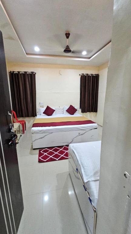 a hotel room with two beds in a room at Godavari Lodge in Solapur