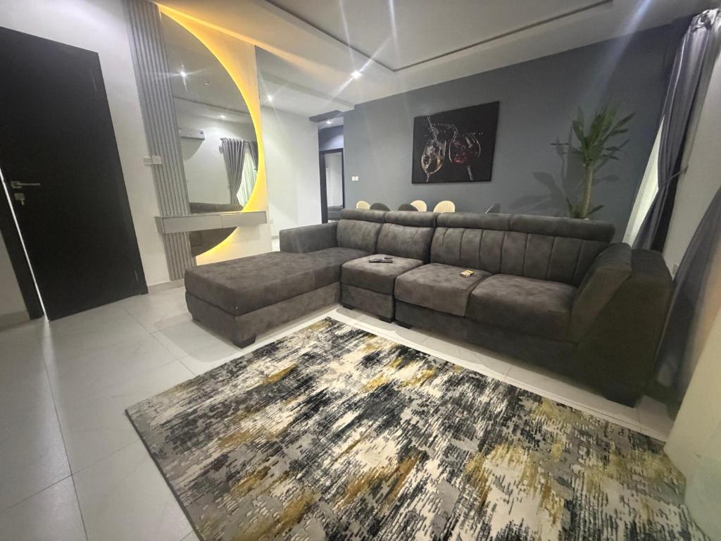 a living room with a couch and a rug at Max Heights, 2 Captivating Bedrooms in Ikeja