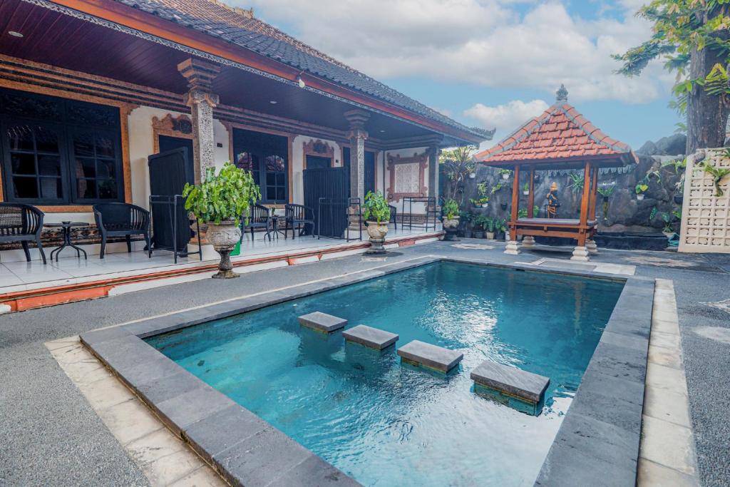 a swimming pool with benches in front of a house at Komala Indah 2 in Badung