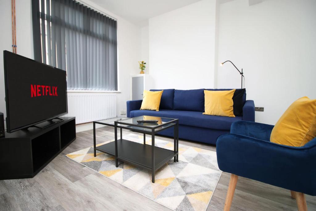 a living room with a blue couch and a tv at Borough Street in Port Talbot