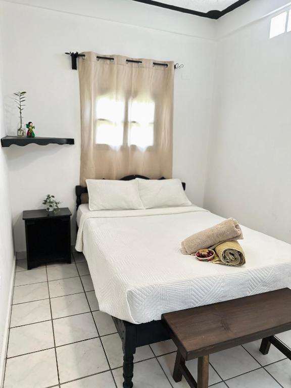 a bedroom with a bed with a table and a window at Guest House Don Moisés in Copán Ruinas