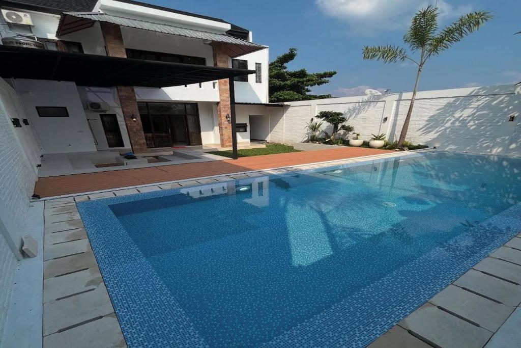 a large blue swimming pool in front of a house at Mega Jaya Villa in Yogyakarta