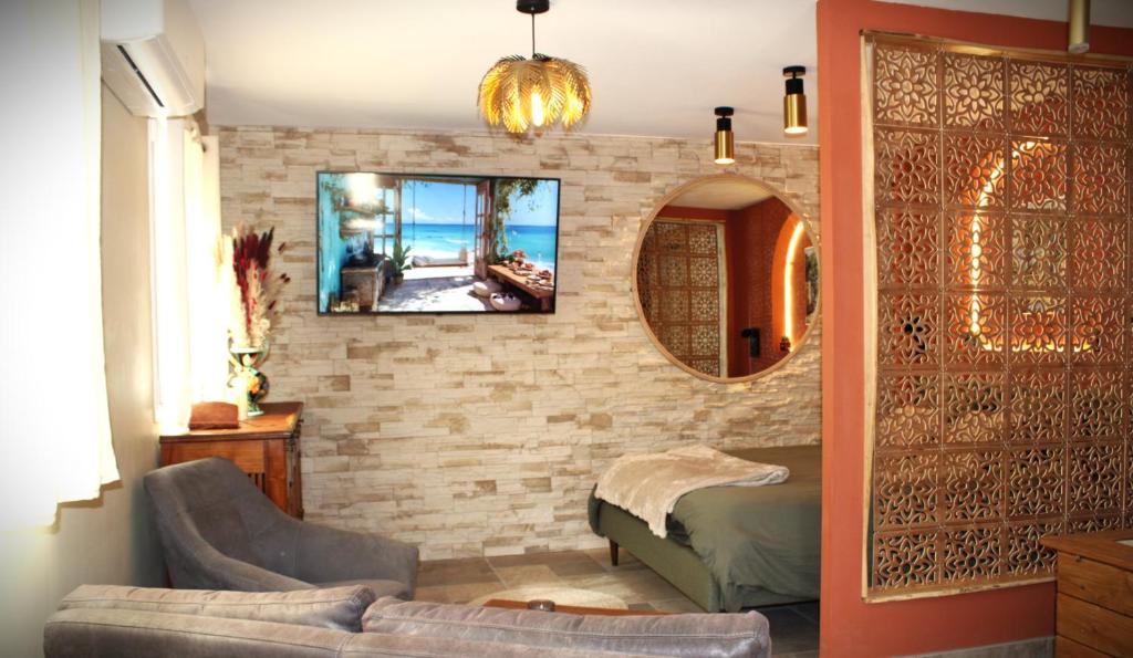 a living room with a mirror on a brick wall at La Casetta refuge méditerranéen et balnéo classé 3 étoiles in Wizernes