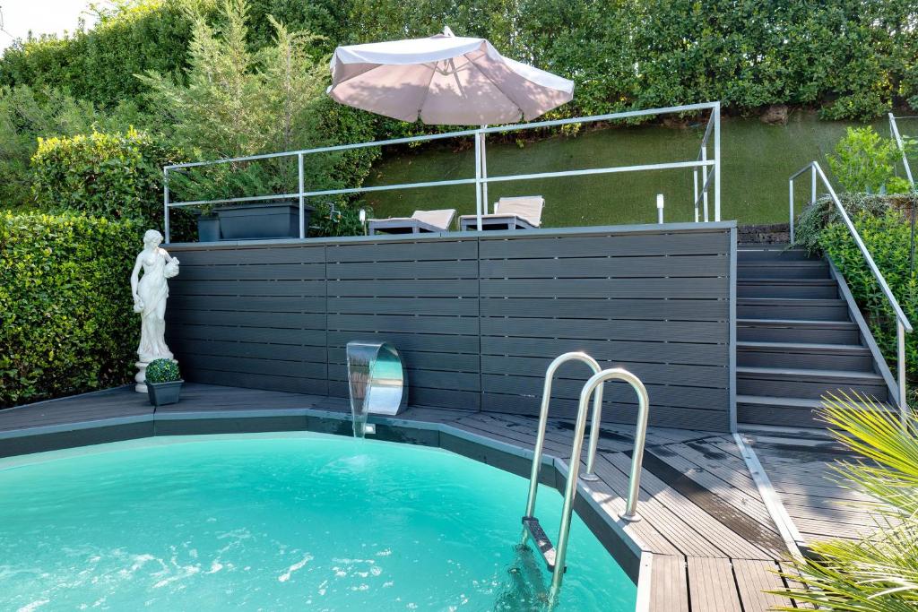 a small swimming pool with an umbrella and stairs at Villa Benaco in Pozzolengo
