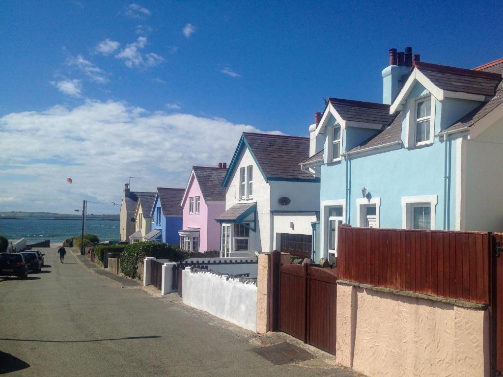 a row of houses on a street next to the ocean at Ty Haf in Rhosneigr