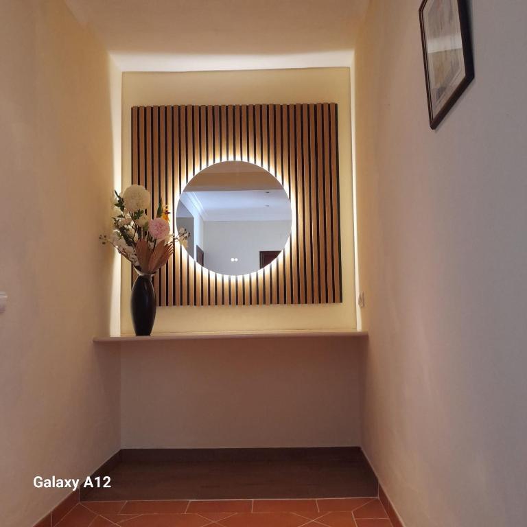 a mirror on a shelf in a room with a vase at Green Ville in Faro