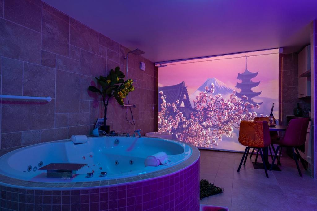 a bathroom with a large tub in a room at Sensori Nuit in Grand-Champ