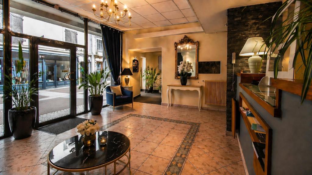 a living room with a table and a couch at Hôtel du Palais in Évian-les-Bains