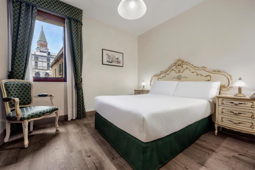 a bedroom with a bed and a chair and a window at Hotel Commercio & Pellegrino in Venice