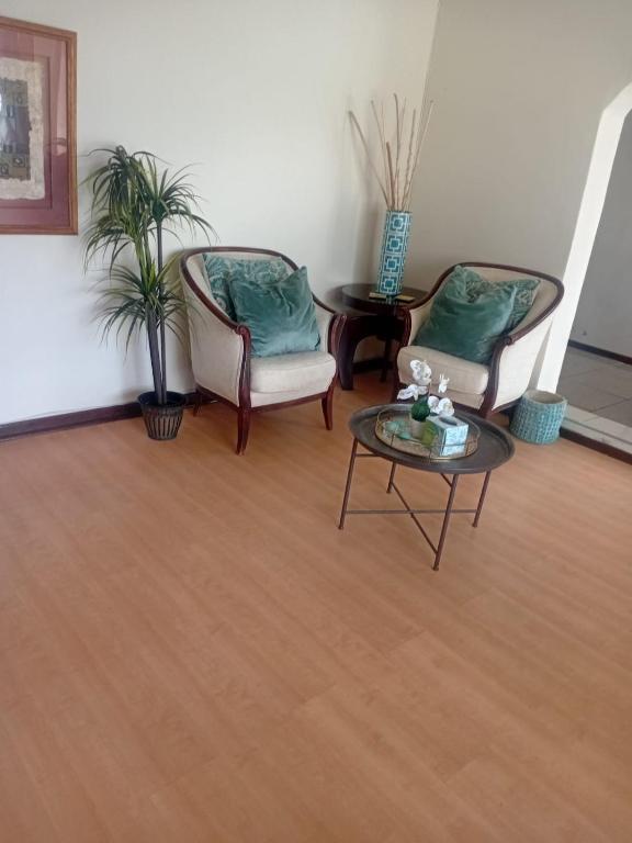 a living room with two chairs and a table at Executive B & B in Beacon Bay