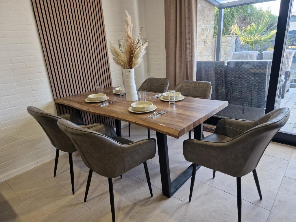 a dining room with a wooden table and chairs at Ferienhaus Holstein in Butjadingen