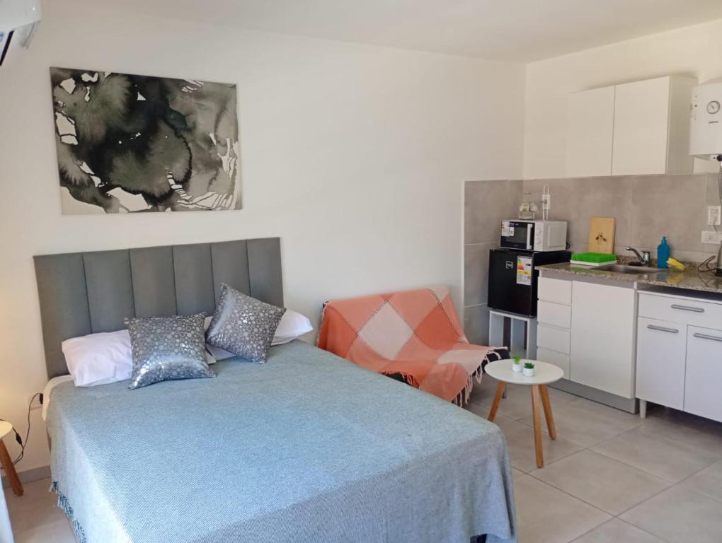 a small bedroom with a bed and a kitchen at APARMENT Paraguay 341 in Rosario