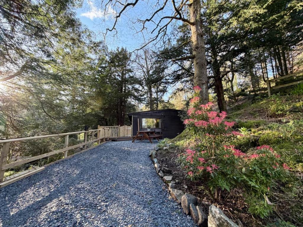 a small cabin with a bench on a walkway at Lake District Woodland Cabin - Close to Ambleside & Langdale Valley in Ambleside