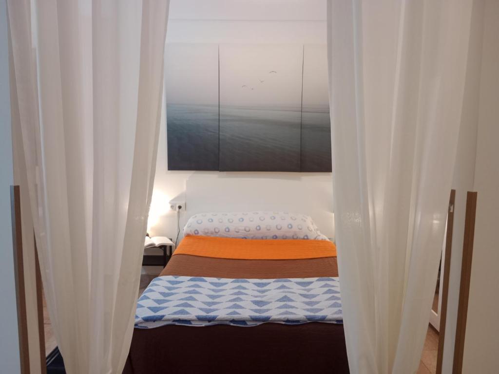 a small bed in a room with white curtains at Loft Centrico - Bahia 2B in Santander