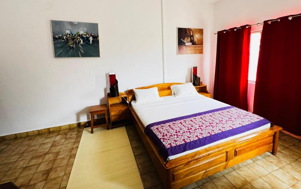 a bedroom with a bed and a red curtain at Hotel Chez Fanny in Palimé
