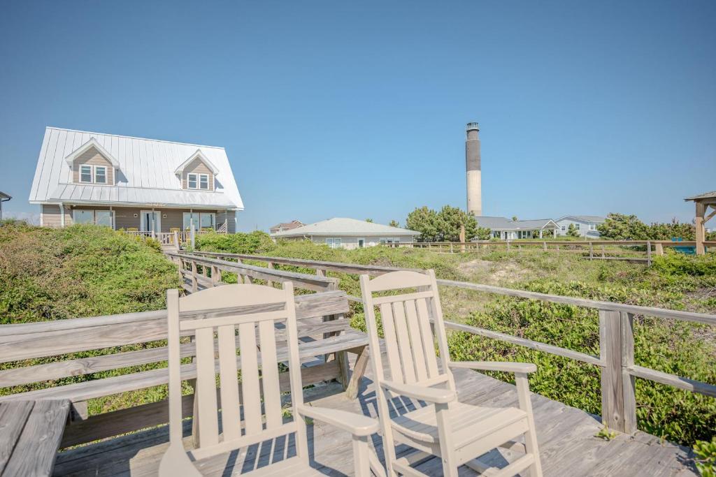 a couple of chairs sitting on a wooden deck at Linger Longer in Caswell Beach