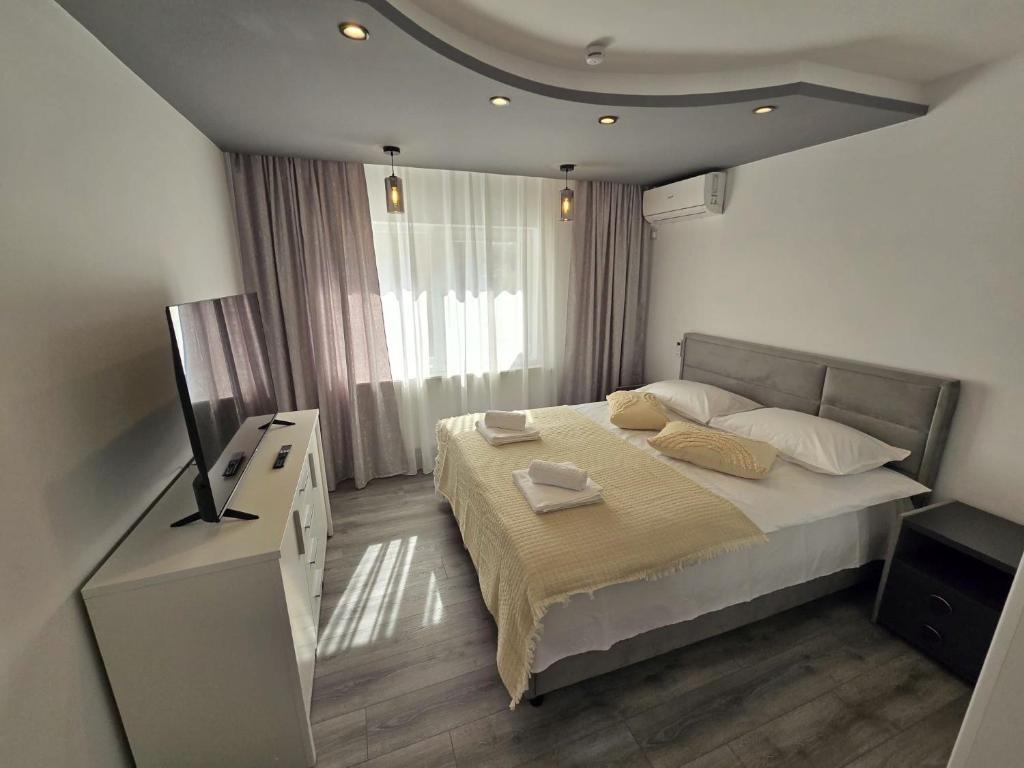 ein Schlafzimmer mit einem großen Bett und einem Fenster in der Unterkunft BlueBee Hive in Orăştie