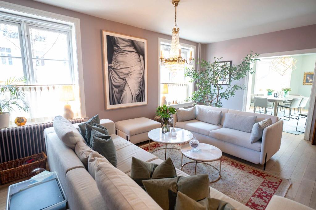 a living room with a couch and a table at Eksklusiv og sjarmerende leilighet på Frogner in Oslo