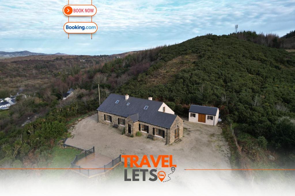 an aerial view of a house on top of a hill at 5 Bedroom House By Travel Lets Holiday Homes Donegal With Sweeping Lake & Hill Views in Carrigart