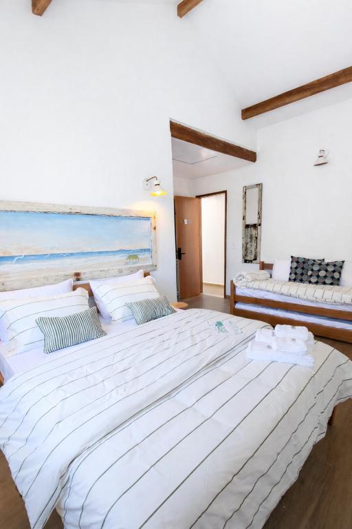 a large white bed in a room with a couch at Morada dos Ventos Búzios in Búzios