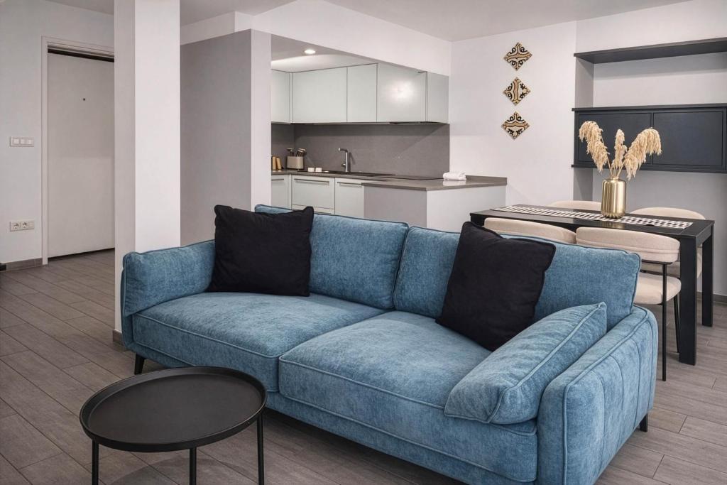 a living room with a blue couch and a kitchen at Maison Michela Sorrento in Sorrento