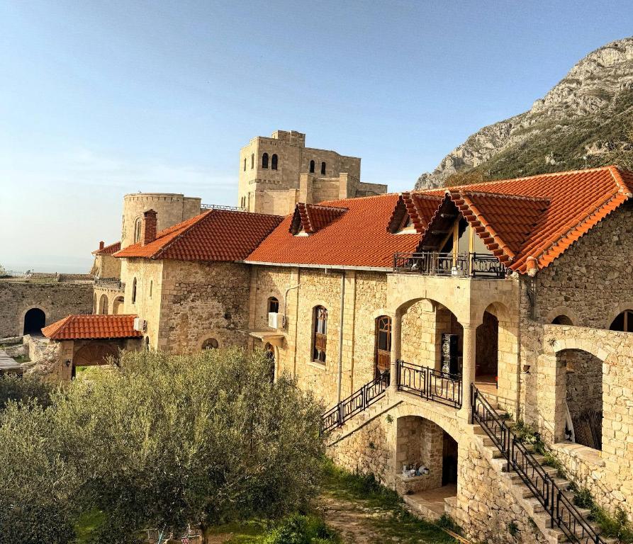 an old stone building with a red roof at Vila Kalaja Kruje, Inside The Castle in Krujë