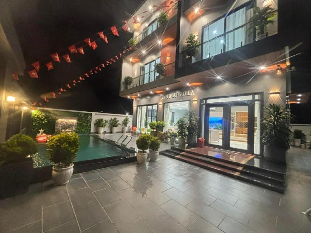 a building with a swimming pool in front of it at Villa Ban Mai in Tài Xá