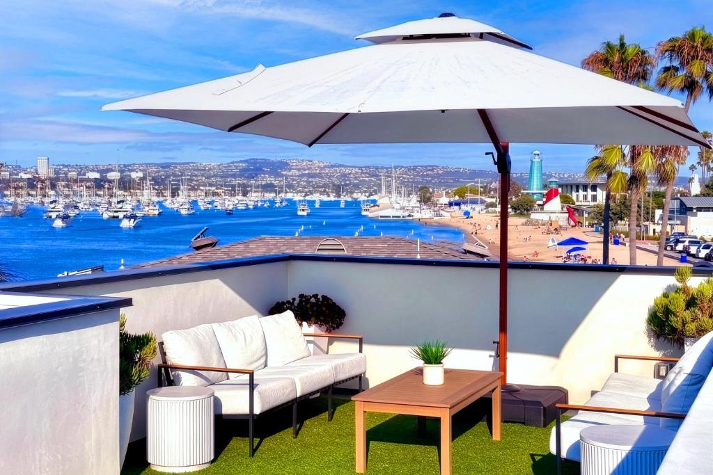 taras z parasolem, krzesłami i stołem w obiekcie Luxury Ocean-View Rooftop | Steps to Beach | A/C w mieście Newport Beach