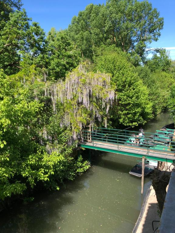 a bridge over a river with people on it at Camping L'îlot du Chail in Sansais