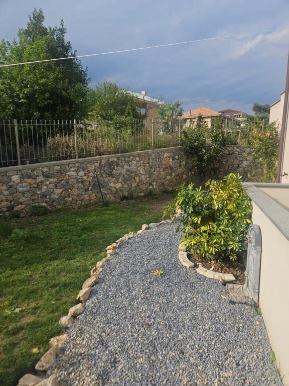 a backyard with a stone wall and a garden at Domus cinque in Borghetto Santo Spirito