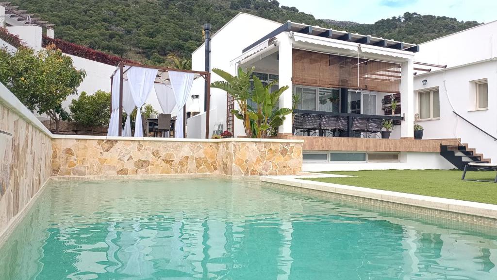 a swimming pool in front of a house at Villa Sueños in Mijas