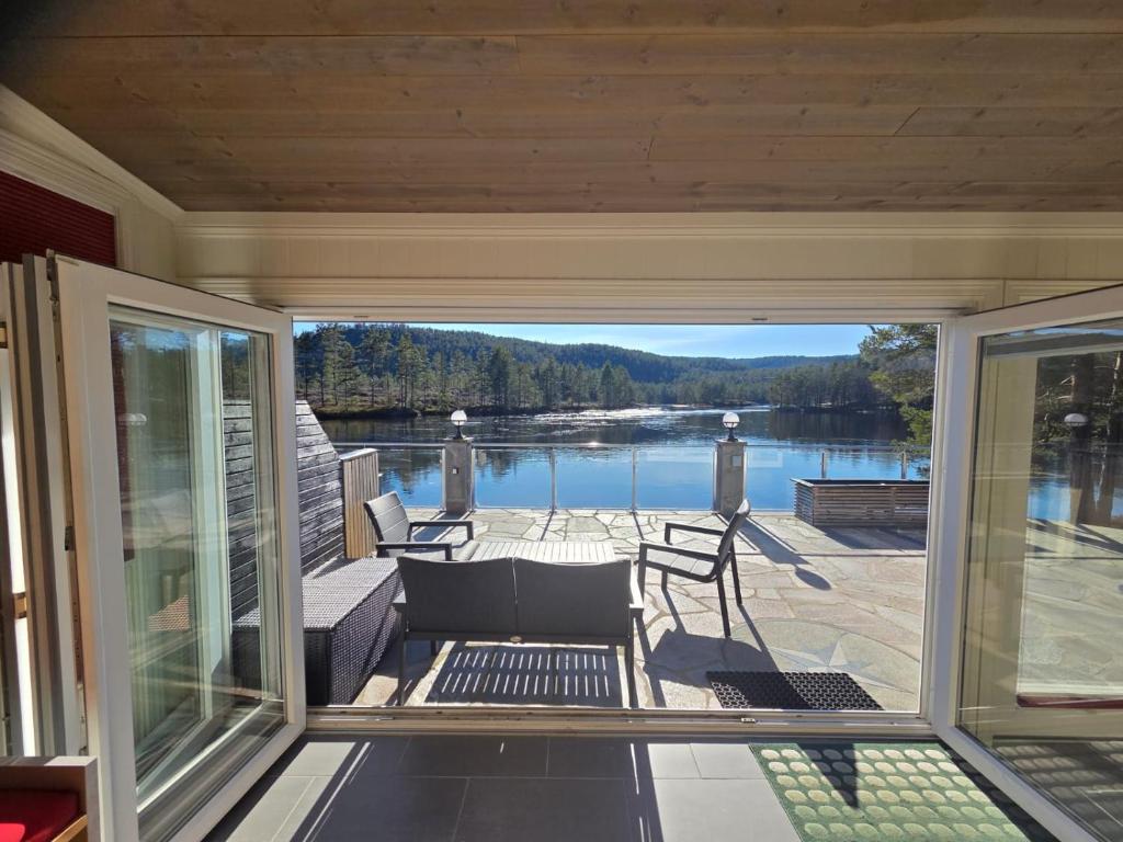 a screened in porch with a view of a lake at Hamsun Panorama med sauna in Åmli