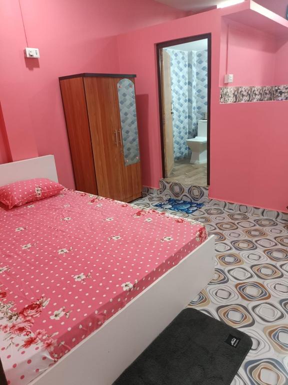 a pink bedroom with a bed and a mirror at Destiny Lodge & Homestay in Nāzirā