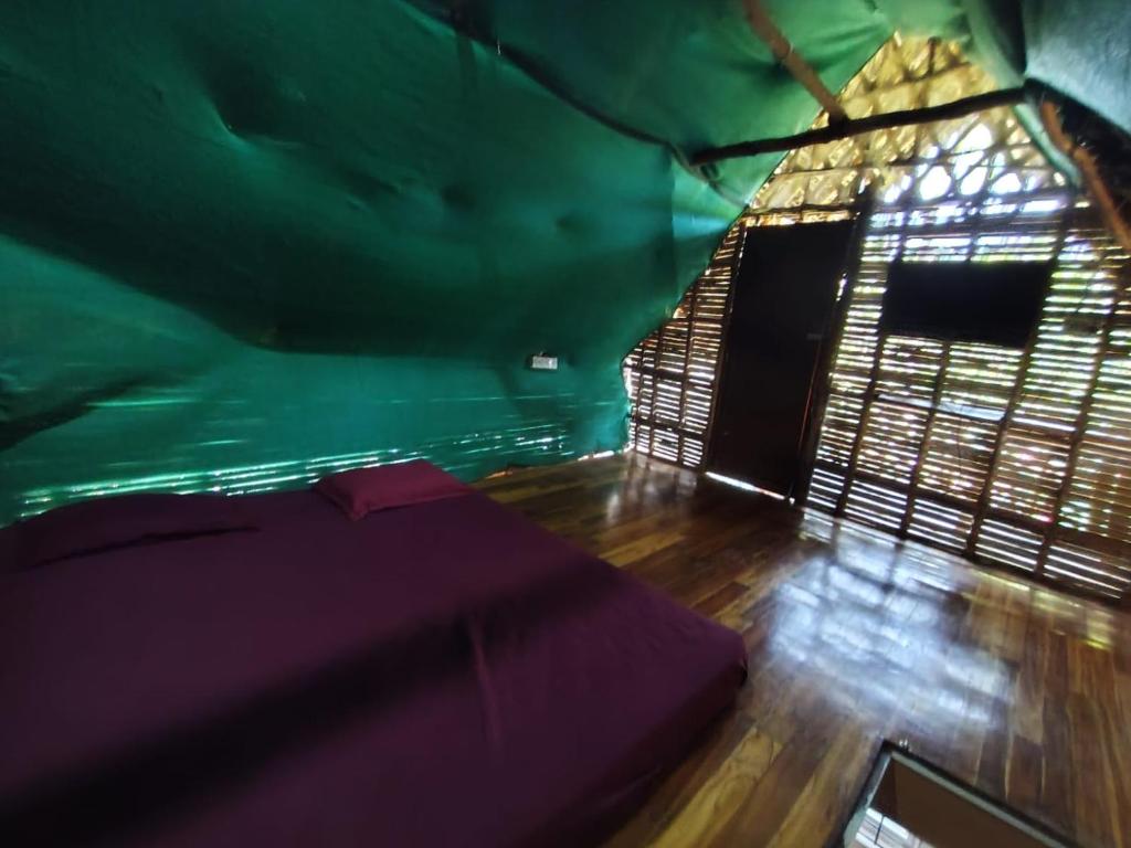 a room with a bed in a green room at Search hurt stays in Kuilapayam
