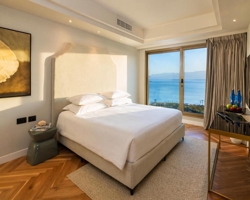 a bedroom with a large bed and a large window at חדר על הים בהרצליה in Herzliya B
